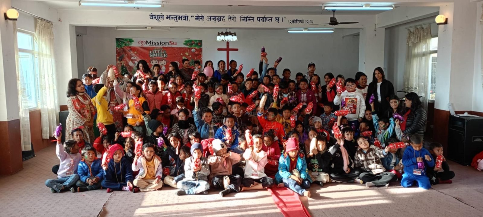 Children receiving Christmas gifts in front of a cross